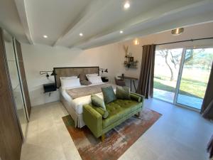 a bedroom with a bed and a green couch at Le Hameau des vanades in Ampus