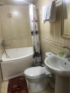 y baño con aseo blanco y lavamanos. en Meros Boutique Hotel, en Samarkand