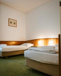 
a hotel room with two beds and two lamps at Hotel Am Sachsengang in Groß-Enzersdorf
