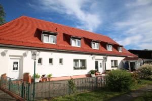 ein weißes Haus mit rotem Dach in der Unterkunft Hotel Landhaus Nassau in Meißen