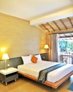 um quarto com uma cama grande e uma janela em WARISAN Heritage Boutique Hotel em Surakarta