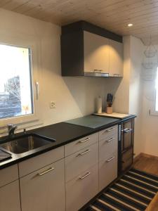 a kitchen with white cabinets and a sink and a window at Distel in Ritzingen