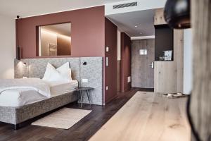 a bedroom with a bed and a mirror on the wall at Haller Suites & Restaurant in Bressanone