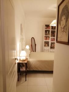 een slaapkamer met een bed en een tafel met een lamp bij Casa Vacanza -Trani centro in Trani