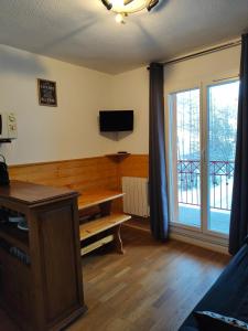 a living room with a table and a sliding glass door at Foux d Allos - Studio au cœur de la station in La Foux