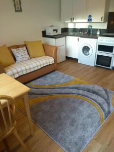 a living room with a couch and a kitchen at Garden Apartment in Didcot