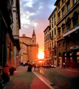 una calle de la ciudad al atardecer con una torre de reloj en Il Balcone Sul Corso en Ancona