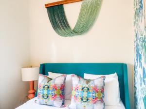 uma cama com uma cabeceira azul com almofadas em Marreros Guest Mansion - Adult Only em Key West