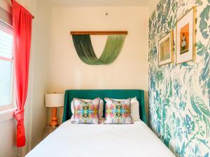 a bedroom with a bed with a green headboard and pillows at Marreros Guest Mansion - Adult Only in Key West