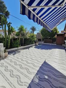 patio con ombrellone blu e bianco di Apartamento totalmente equipado con jardín y WiFi Santa Pola Gran Alacant a Gran Alacant