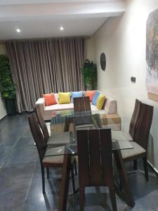 - une salle à manger avec une table et un canapé dans l'établissement Chalet Asmoun 2, à Imouzzer du Kandar