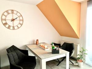 uma sala de jantar com uma mesa e um relógio em Eigenes Apartment im Herzen der Stadt mit Balkon und WLAN III em Cottbus