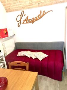 a red couch in a living room with a table at L’arquele in Noci