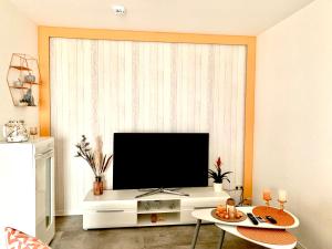 uma sala de estar com televisão num centro de entretenimento branco em Eigenes Apartment im Herzen der Stadt mit Balkon und WLAN III em Cottbus