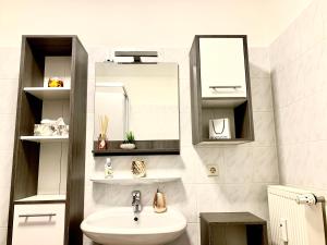 a white bathroom with a sink and a mirror at Eigenes Apartment im Herzen der Stadt mit Balkon und WLAN III in Cottbus