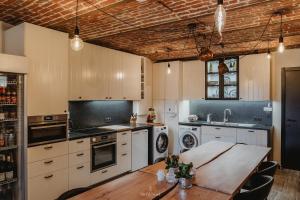 a kitchen with white cabinets and a wooden table at Gavershof in Geraardsbergen