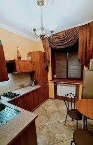 a kitchen with wooden cabinets and a table and a window at PremierAtlant in Dnipro