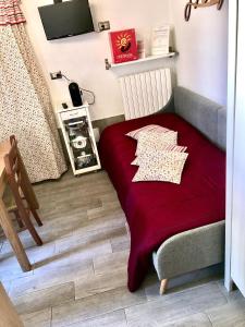 a bed in a room with a red blanket at L’arquele in Noci