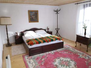 een slaapkamer met een groot bed en een tapijt bij Тихия кът in Malchovtsi +17 foto's
