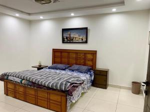 a bedroom with a bed and a picture on the wall at Dha hotel apartments families only in Rawalpindi