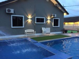 une maison avec une piscine devant une maison dans l'établissement MELAKA BEACH VILLA ( A TYPE ), à Kelebang Besar