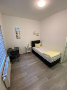a small bedroom with a bed and a table at Apartment Dusseldorf-City in Düsseldorf
