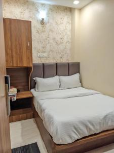 - une chambre avec un grand lit et une tête de lit marron dans l'établissement Hotel Samrat Ajmer, à Kokkíni Khánion