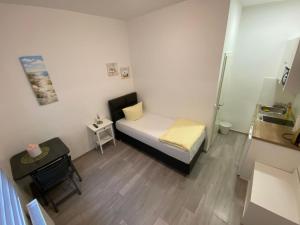 - une petite chambre avec un lit et une table dans l'établissement Apartment Dusseldorf-City, à Düsseldorf
