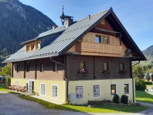 a large wooden house with a gambrel roof at Bauernhof - Appartement beim Zefferer in Schladming