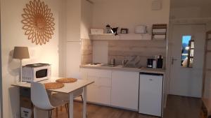 een kleine keuken met een tafel en een magnetron bij Studio vue panoramique sur mer in Villers-sur-Mer