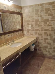 a bathroom with a sink and a mirror at departamento del centro in La Falda