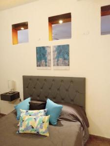 ein Schlafzimmer mit einem Bett mit drei Bildern an der Wand in der Unterkunft departamento del centro in La Falda