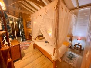 una camera con letto e rete di Villa Gaïa - Bungalow Ti-Spa et son jacuzzi privé dans un jardin tropical, séjour en amoureux ou en famille a Le Diamant Altre 37 foto