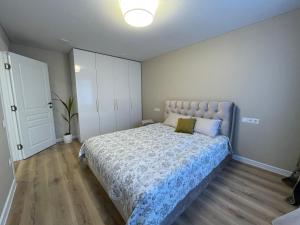 a bedroom with a large bed and a white cabinet at Apartamentai 128 in Panevėžys