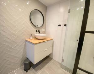 een badkamer met een wastafel en een spiegel bij B&B Freydag in Rheden