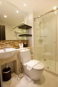 e bagno con servizi igienici, lavandino e doccia. di Prestige Suites Nana a Bangkok