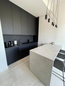 a kitchen with black and white cabinets and a counter at Apartament 8015 in Jelenia Góra