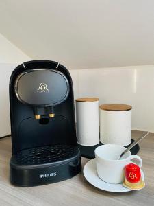 een koffiezetapparaat met een kopje en twee kopjes op een tafel bij le Seize B in Épernay