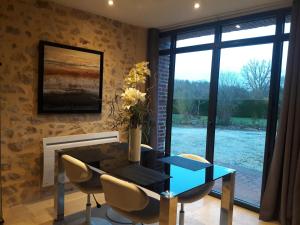 uma sala de jantar com uma mesa e um vaso de flores em TUILERIE DE LA COTE 4* em Ouzouer-sur-Trézée