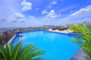 a large blue swimming pool on top of a building at Pipul Padmaja Premium Hotel in Bhubaneshwar