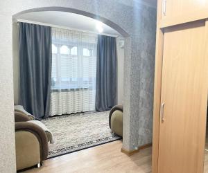 sala de estar con ventana grande y puerta en Apartment on Astana 12/1, en Öskemen