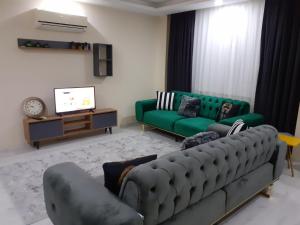 a living room with a green couch and a tv at Canan Residance in Demre