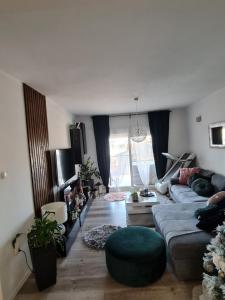 uma sala de estar com um sofá e um repousa-pés verde em Luxury Apartments Mia em Podstrana