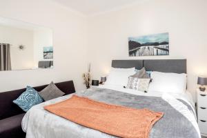 um quarto com uma cama grande e almofadas em MPL Apartments - Malden Road Serviced Accommodation em Watford