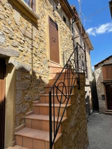 a stone building with a staircase leading to a door at Il castagno in Vico nel Lazio