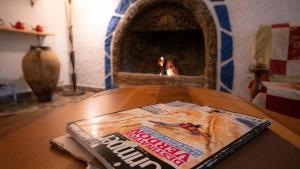 a magazine sitting on top of a table with a fireplace at vita campıng otel in Geyikbayırı