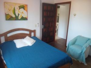 Apartamento com varanda في فلوريانوبوليس: غرفة نوم بسرير ازرق وكرسي