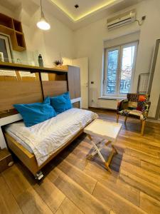 a bedroom with a bed with blue pillows and a table at The Bohemian Residence in Belgrade
