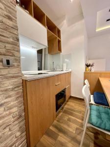 a kitchen with wooden cabinets and a sink and a table at The Bohemian Residence in Belgrade
