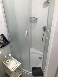y baño con ducha y puerta de cristal. en Apartamentai Nidos centre Taikos g, en Nida